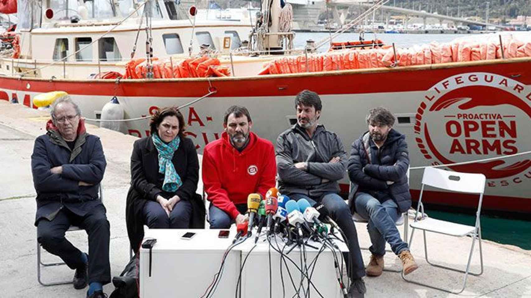 El fundador de la ONG Proactiva Open Arms, Òscar Camps (c), acompañado del cantante Joan Manuel Serrat (i), la alcaldesa de Barcelona, Ada Colau (2i), el expresidente del Joventut de Badalona, Jordi Villacampa (2d) y el periodista Jordi Évole (d) / EFE
