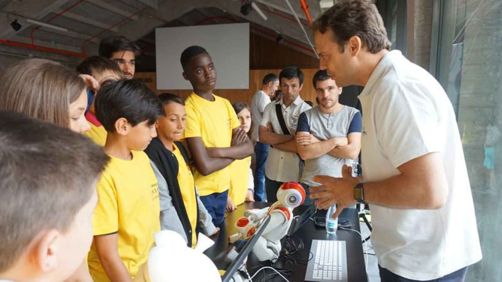 El CEO de Casual Robots, Pablo Medrano, explica a un grupo de niños conocimientos de programación para robots.