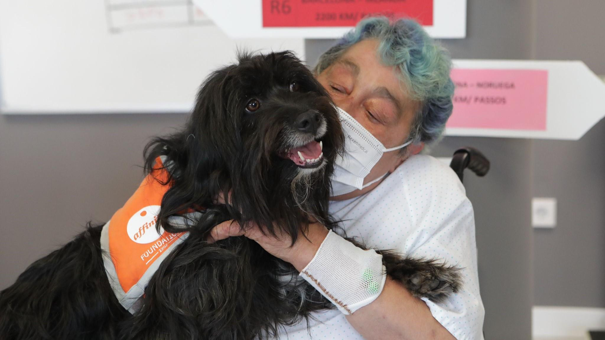 Una mujer realiza la terapia con uno de los canes para mejorar su estado emocional antes de recibir el alta médica / FUNDACIÓN AFFINITY