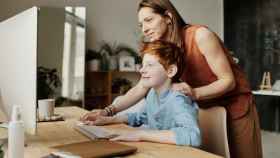 Una madre instruye a su hijo en el uso del ordenador / PEXELS