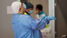 Un sanitario se prepara antes de iniciar su jornada laboral en el Pabellón 9 del hospital de campaña de Ifema / EP