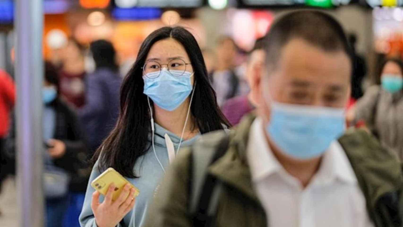 Personas con mascarilla en un aeropuerto de China, que prohíbe los viajes organizados por el coronavirus / EP