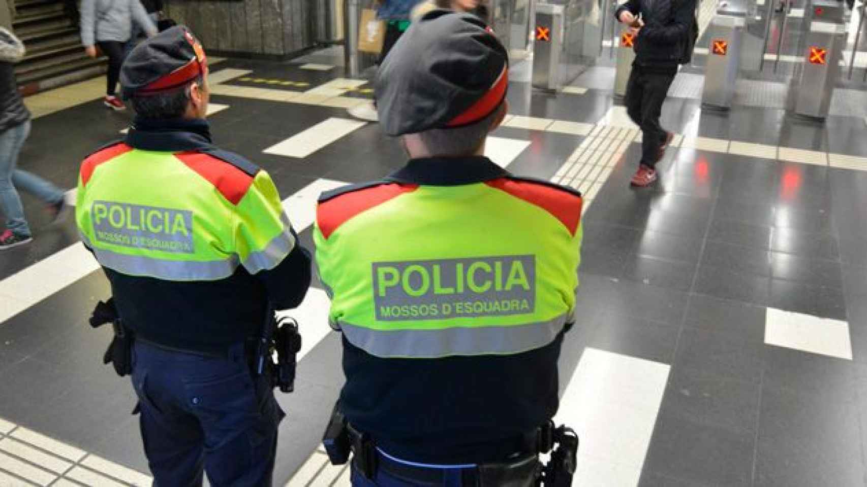 Dos agentes de los Mossos d'Esquadra custodian un acceso a una parada de metro en el Eixample de Barcelona / CG