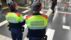 Dos agentes de los Mossos d'Esquadra custodian un acceso a una parada de metro en el Eixample de Barcelona / CG