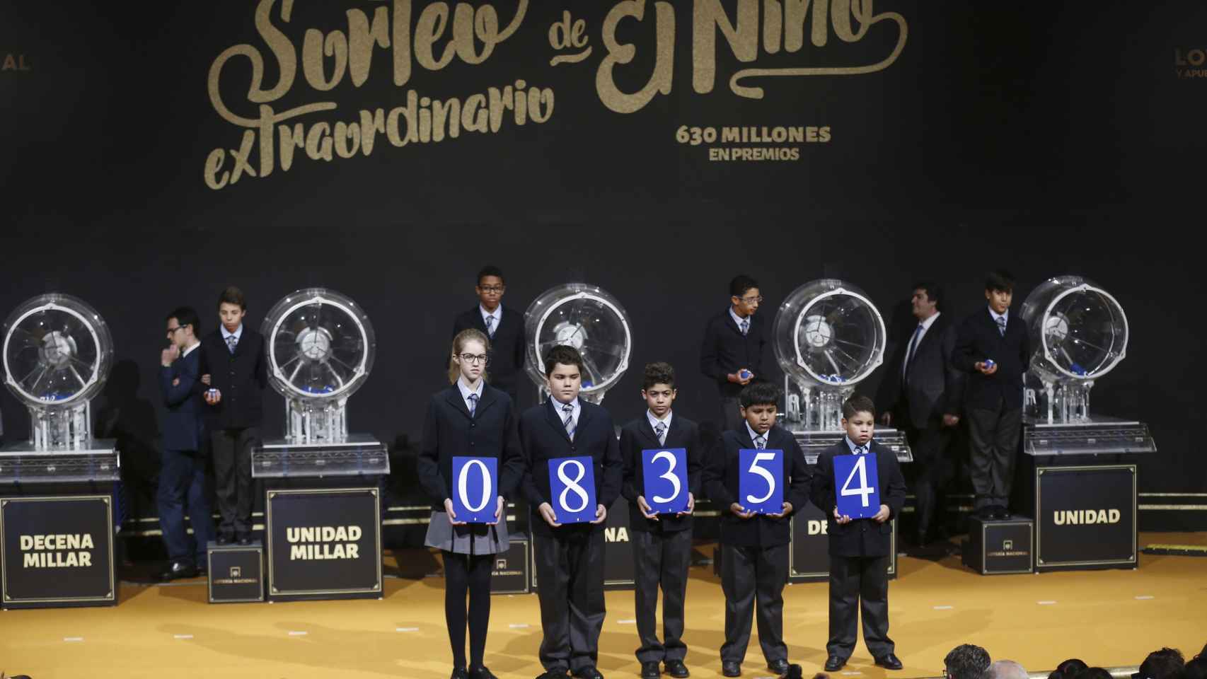 Cinco niños posan con el número ganador del primer premio del sorteo del Niño 2017 / EFE