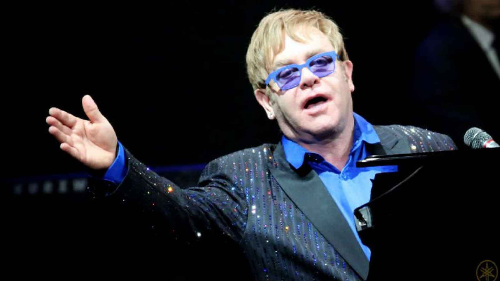 El músico Elton John tocando el piano durante uno de sus conciertos.