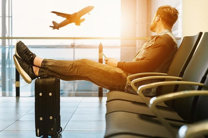 Hombre esperando en el aeropuerto con su tarjeta de embarque / Jan Vašek EN PIXABAY
