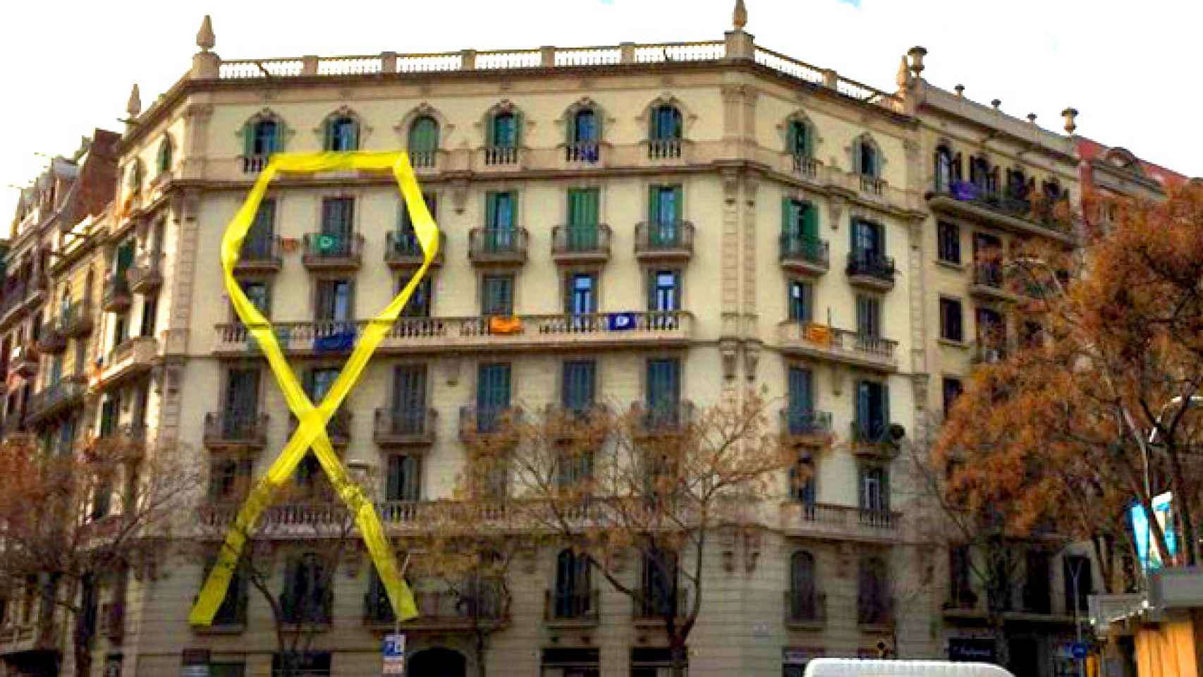 Lazo amarillo en la fachada de un edificio entre la calle Mallorca y Sicilia. Las comunidades de vecinos deben autorizar las banderas / CG