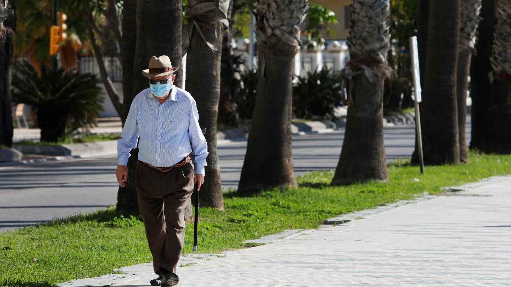 Personas mayores pasean por la calle protegidos con mascarillas por el coronavirus / EP