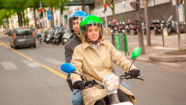 Dos personas se desplazan en una moto de Cooltra por Barcelona / EP