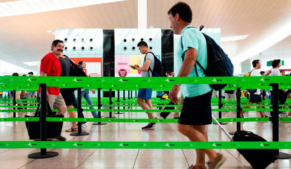 Varios pasajeros pasan el control de seguridad del aeropuerto de El Prat