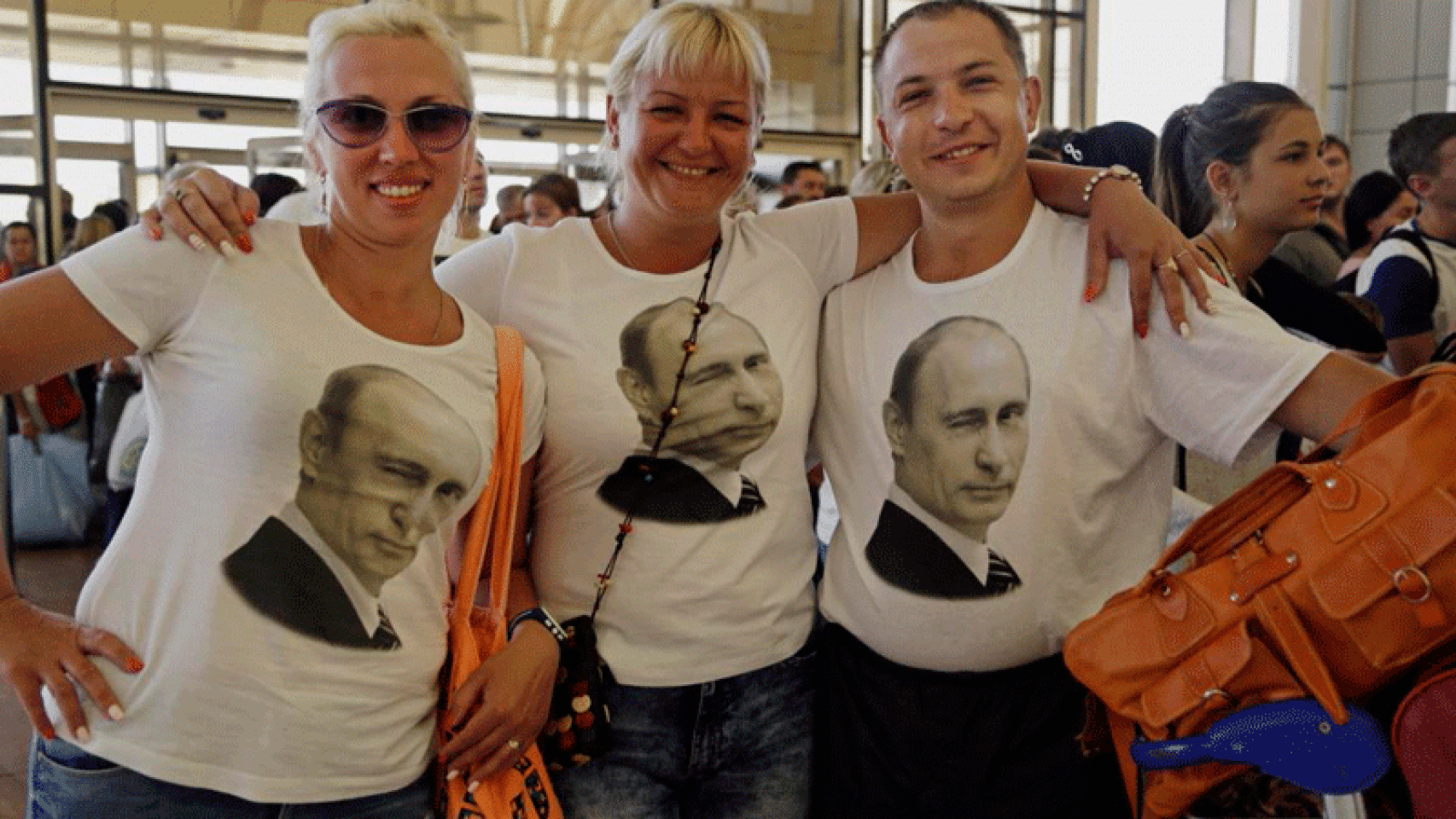 Turistas rusos con camisetas en las que se ve la imagen del presidente de su país, Vladimir Putin.
