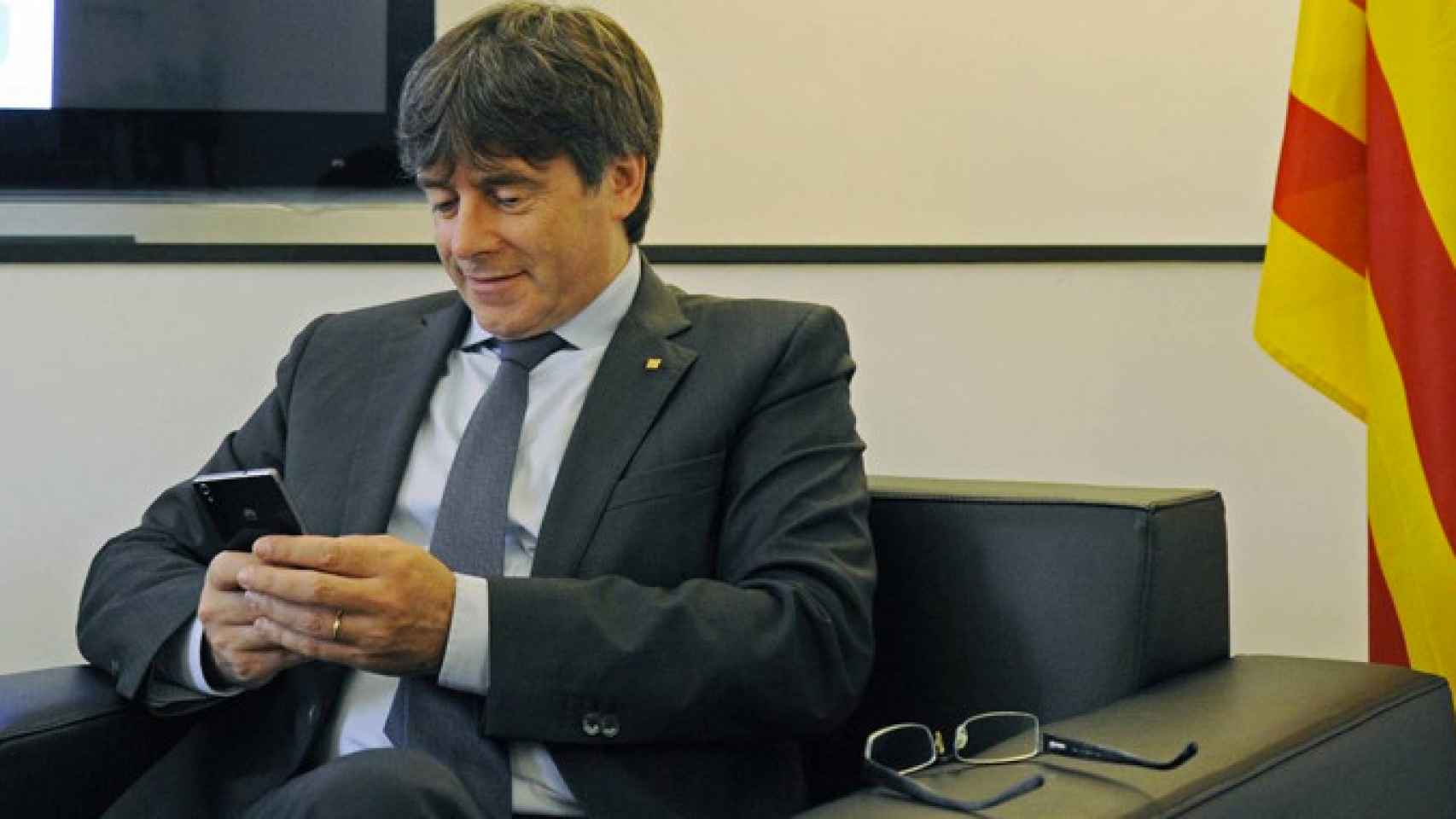 Carles Puigdemont consulta su móvil en una imagen de archivo / EFE