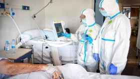 Médicos protegidos con trajes EPI tratan a un paciente con coronavirus / EP