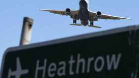 Un avión sobrevuela un cartel mientras se prepara para aterrizar en el Aeropuerto de Heathrow, el principal de Londres / EFE