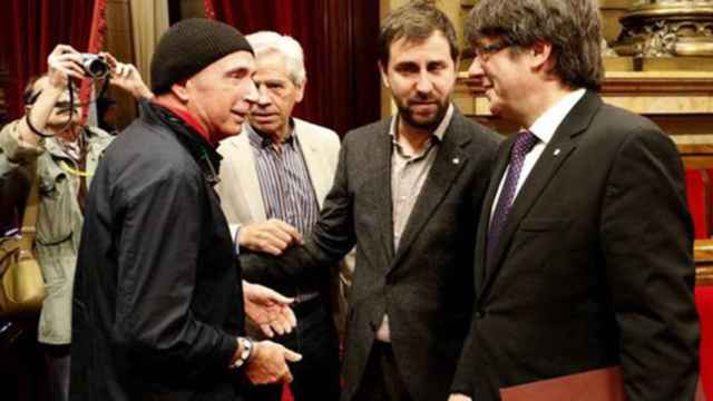 El exdiputado de JxS Lluís Llach saluda al expresidente Carles Puigdemont en el Parlament / EFE