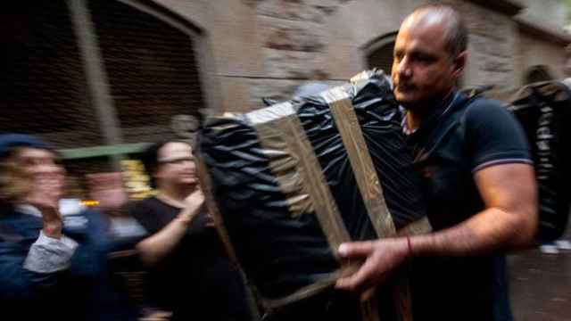 Un voluntario carga una urna envuelta en plástico en un colegio electoral para el referéndum ilegal del 1-O en Cataluña / EFE