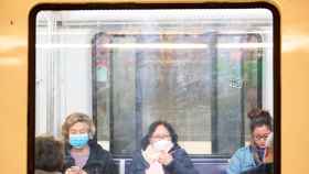 Varios pasajeros en el transporte público con mascarilla / EFE
