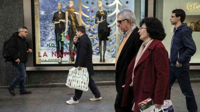 Varios viandantes pasan por delante de un comercio en diciembre, cuando aumentaron las ventas / EFE