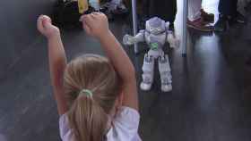 Uno de los robots Nao Therapist interactúa con una niña.