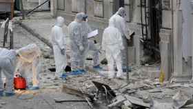 Policías investigan la entrada de la Federación de Empresas Industriales de Grecia tras la explosión de una bomba.