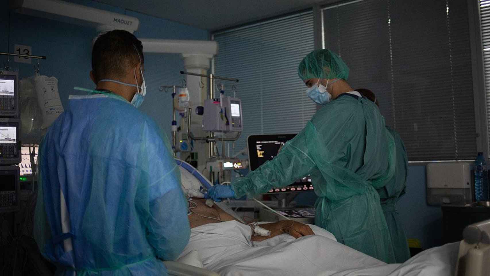 Personal sanitario visita a un paciente ingresado en la uci del Hospital de la Santa Creu i Sant Pau de Barcelona / David Zorrakino (EP)