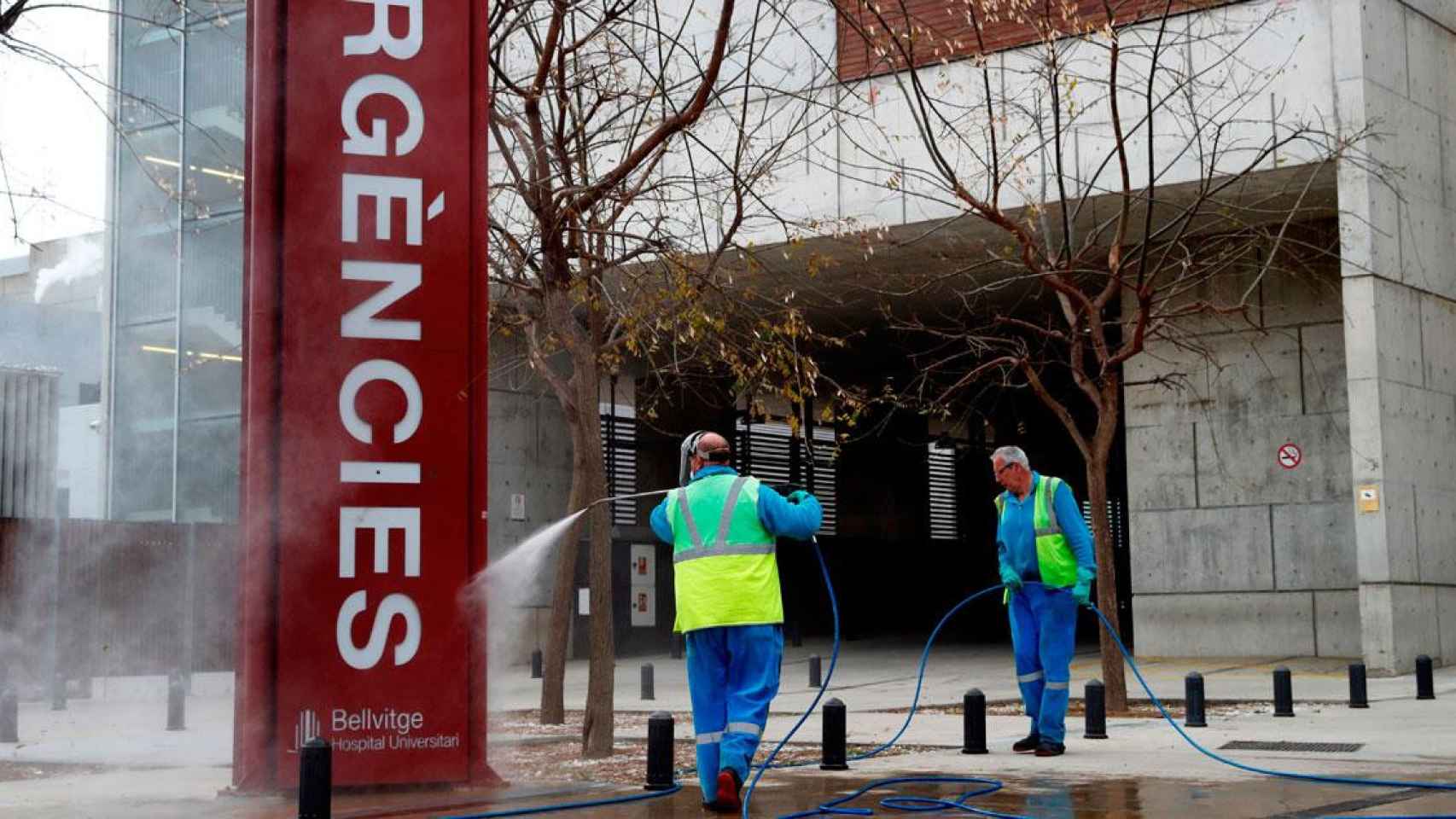 Imagen de operarios de limpieza desinfectando la entrada a Urgencias del Hospital Universitari de Bellvitge (HUB) / EFE