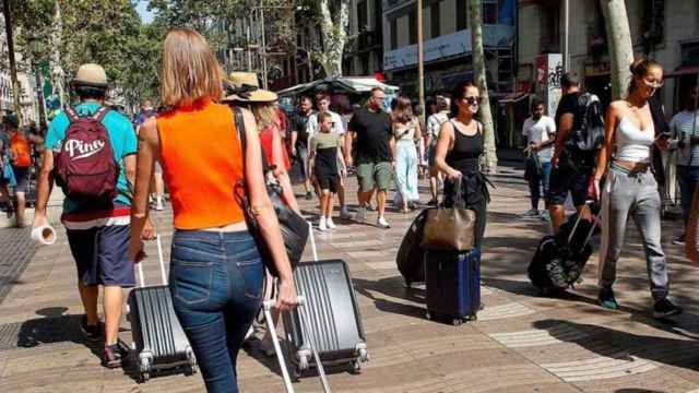 Turistas paseando con sus maletas en Las Ramblas de Barcelona