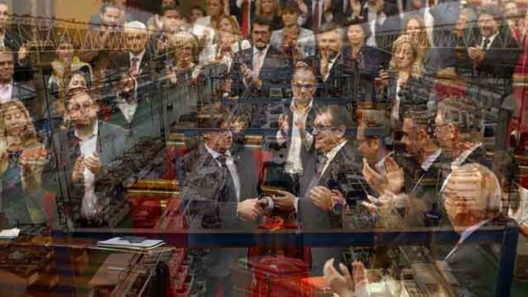 El presidente de la Generalitat, Carles Puigdemont (c), tras una votación en el Parlamento y una imagen de la factoría de Nissan en Barcelona / FOTOMONTAJE DE CG