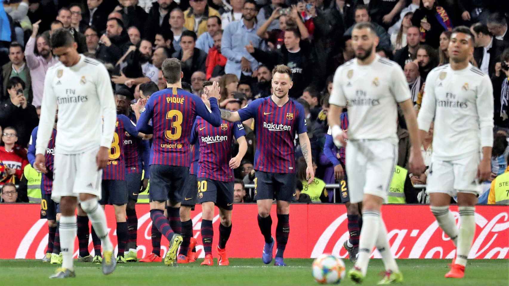 Los futbolistas del FC Barcelona celebran un tanto ante la decepción del Real Madrid / EFE