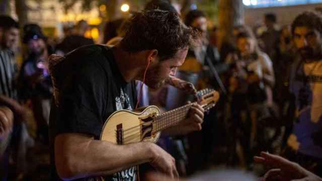 Imagen de un hombre tocando un instrumento durante un botellón en las Fiestas de Sants / EP
