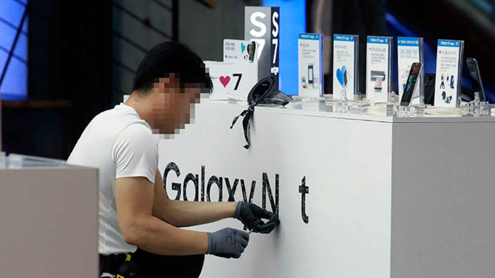 Un empleado retira la marca publicitaria de Galaxy Note 7 en una tienda en Seúl (Corea del Sur) | EFE