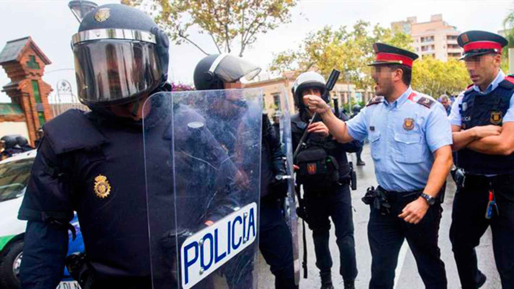 Policía Nacional y Mossos d'Esquadra en las afueras de un centro de votación de la Escuela Secundaria Can Vilumara de L'Hospitalet Llobregat / EFE