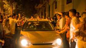 Decenas de personas rodean a un vehículo que circula por una calle del barrio de Gràcia esta madrugada / LORENA SOPENA - EUROPA PRESS