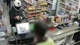 Uno de los atracadores roba el dinero de la caja de una gasolinera / TWITTER MOSSOS