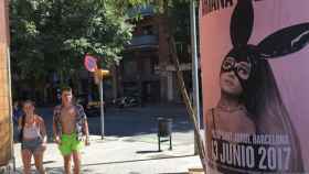 Unos turistas aprecian el cartel que anuncia el concierto de Ariana Grande en Barcelona en la calle Sardenya / CG