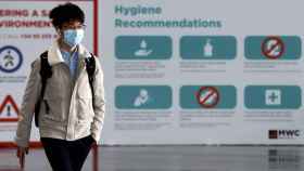 Una persona pasea ante las recomendaciones de higiene del Mobile por el coronavirus / EFE