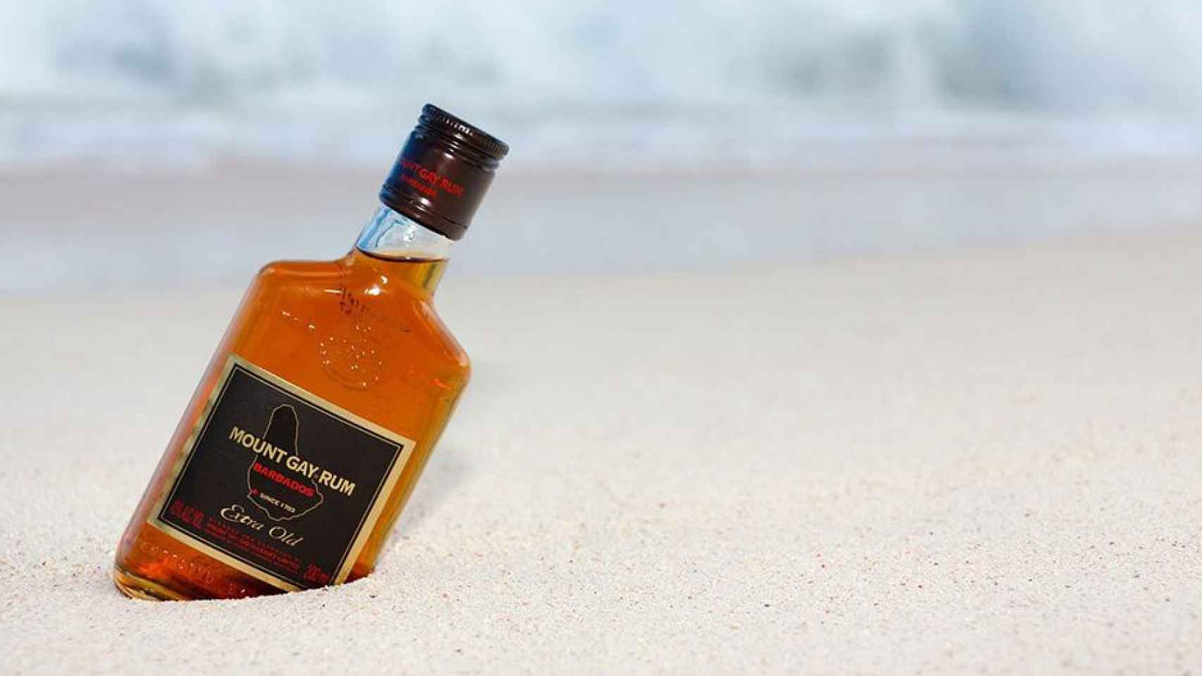 Botella de ron en la playa / PIXABAY