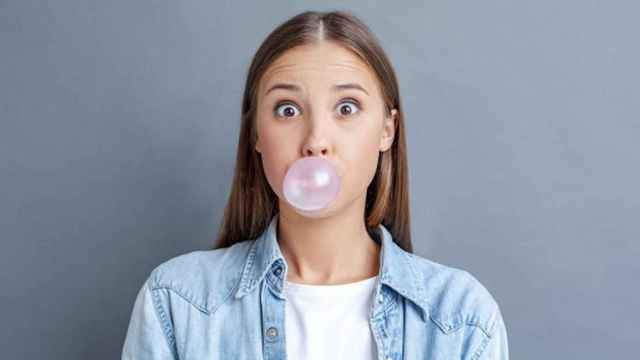 Una foto de una joven mascando chicle, uno de los nueve hábitos