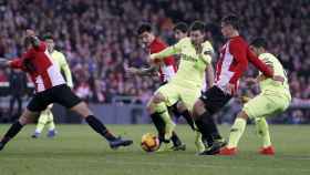 Leo Messi disputando un balón con los jugadores del Athletic Club / EFE