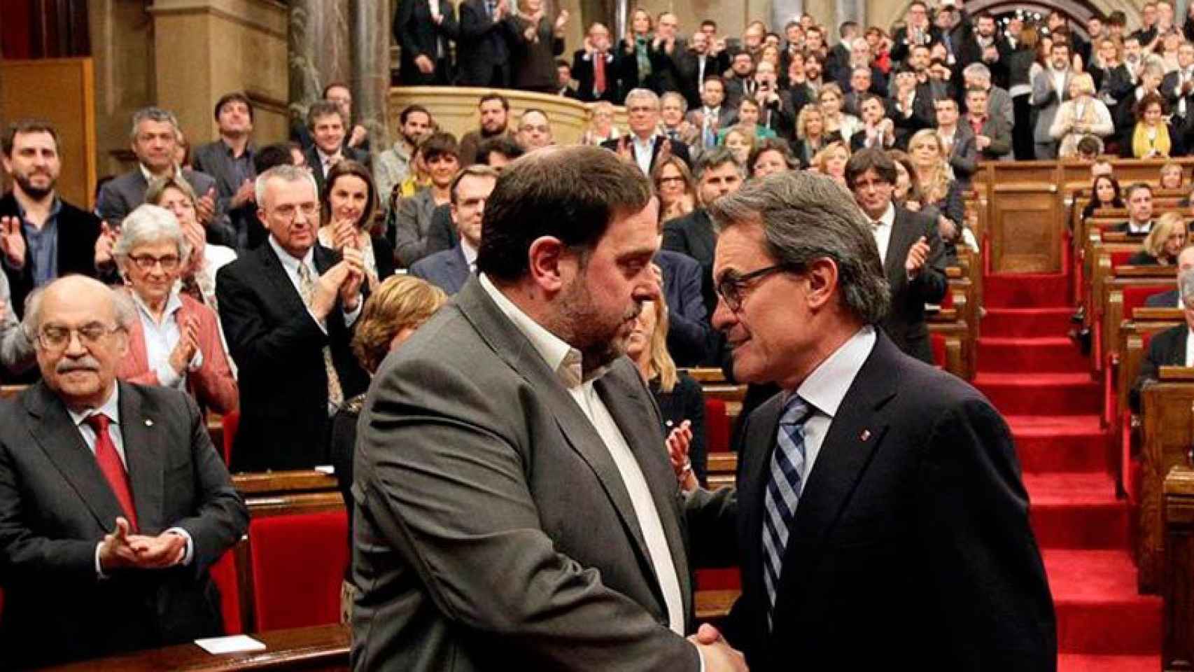 Imagen de archivo de Oriol Junqueras y Artur Mas saludándose al inicio de una sesión plenaria de investidura.