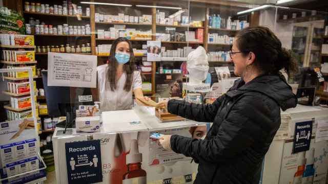 Una dependienta atiende a una clienta en una farmacia, Farmacias / EP