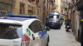 Vehículos de la Urbana y de los Mossos apostados bajo el piso en el que se ha desplegado el operativo en Ciutat Vella / MOSSOS