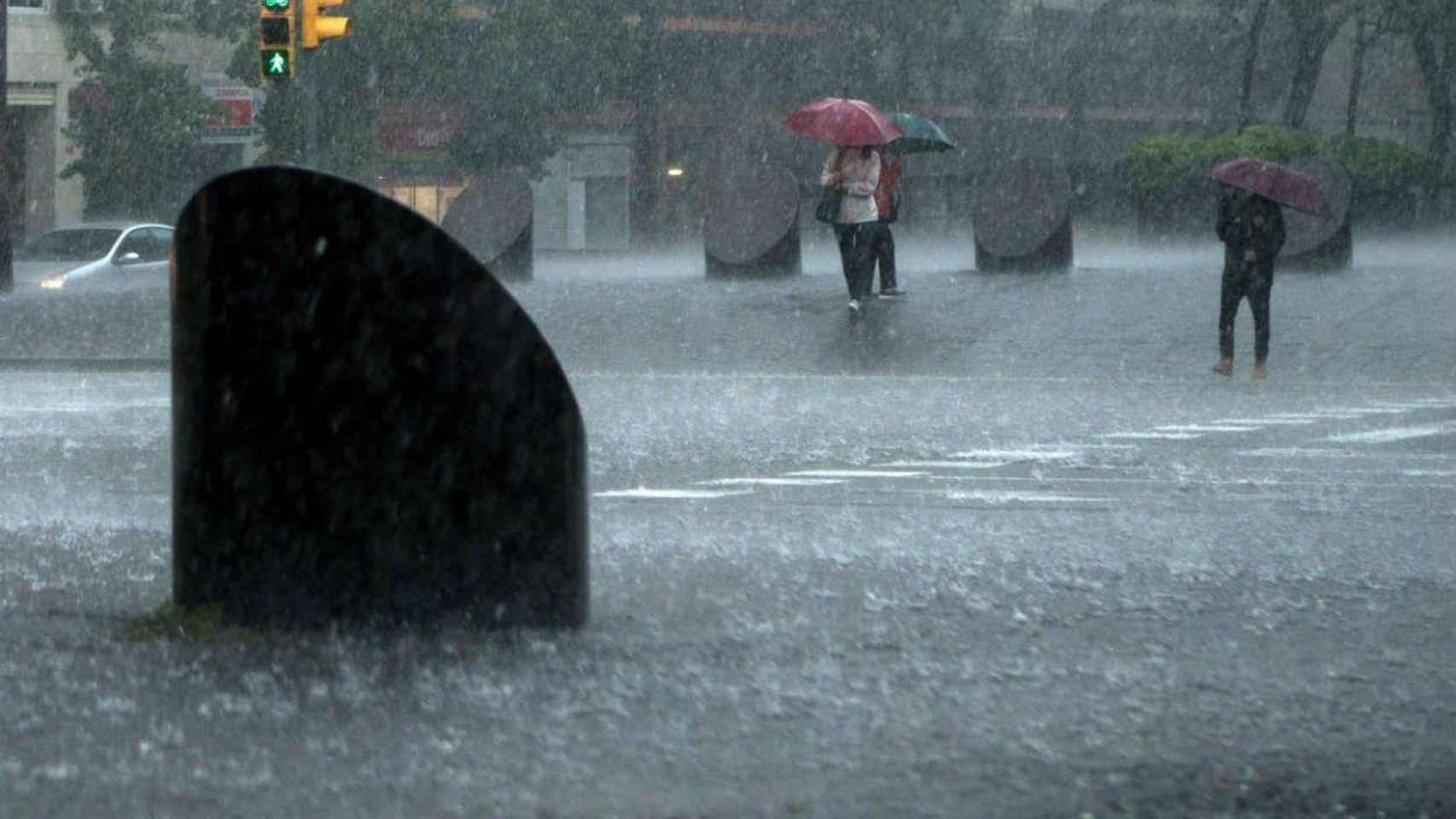 Varias personas cruzan la calle en un día de lluvia / EFE
