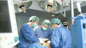 Tres médicos llevan a cabo una intervención quirúrgica en una imagen de archivo. / EFE