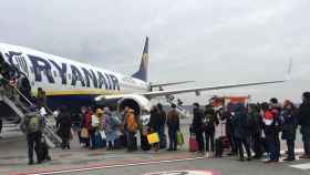Sector turístico. Un avión de Ryanair con una cola de pasajeros  / EE