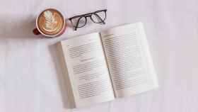 Taza de café, gafas, y libro abierto preparado para su lectura / UNSPLASH