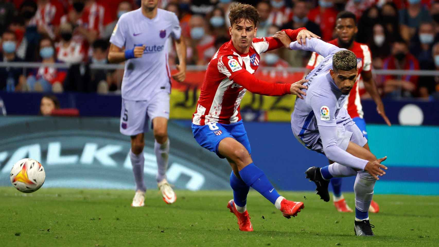 Griezmann luchando un balón con Araujo del Barça en el Wanda / EFE