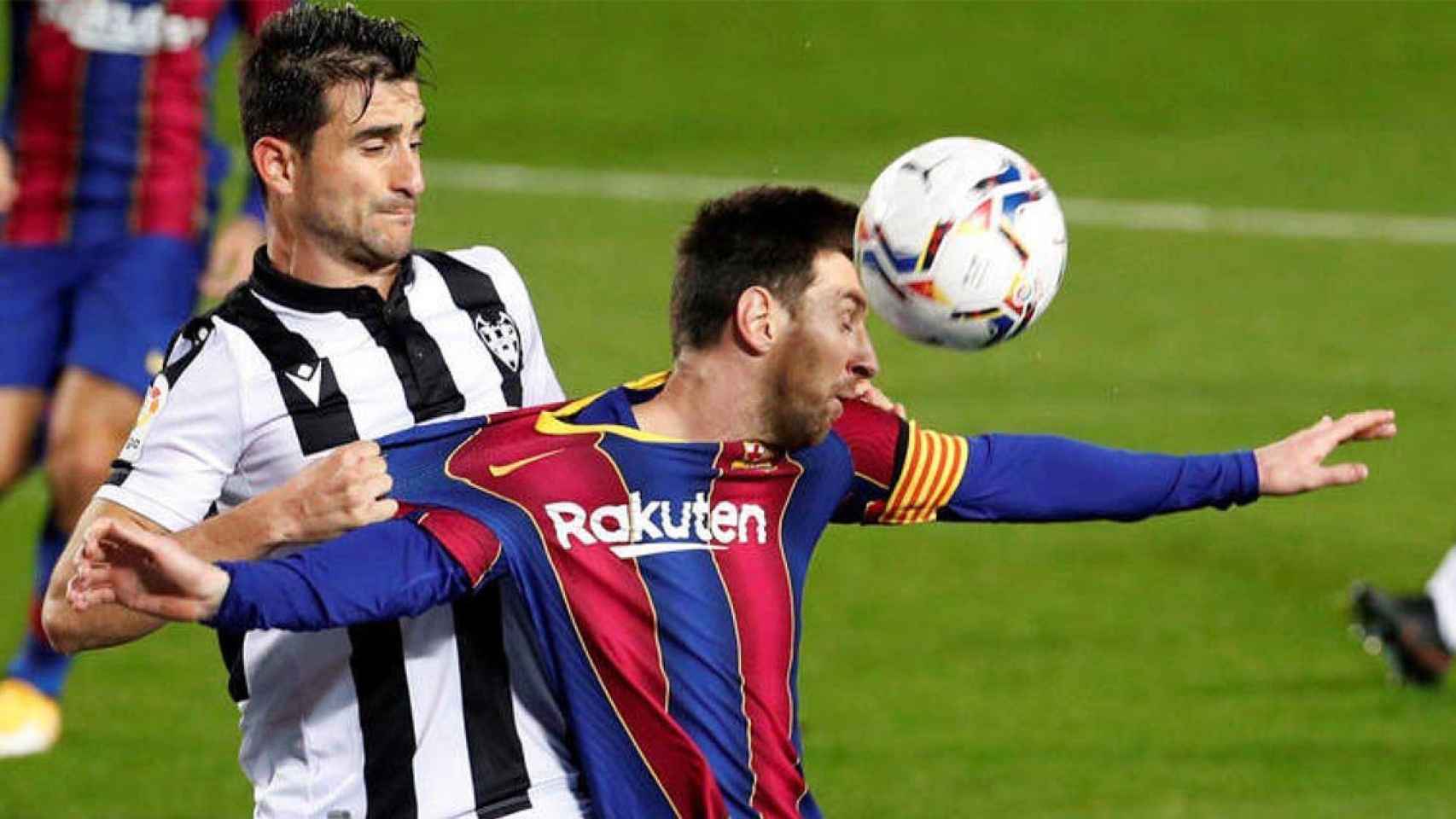 Agarrón de Sergio Postigo a Lionel Messi dentro del área en el encuentro del FC Barcelona contra el Levante / EFE