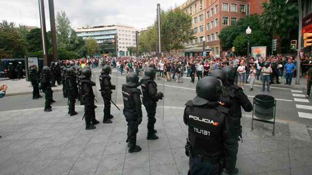 Agentes de la policía nacional forman un cordón policial en el exterior del IES Tarragona / EFE